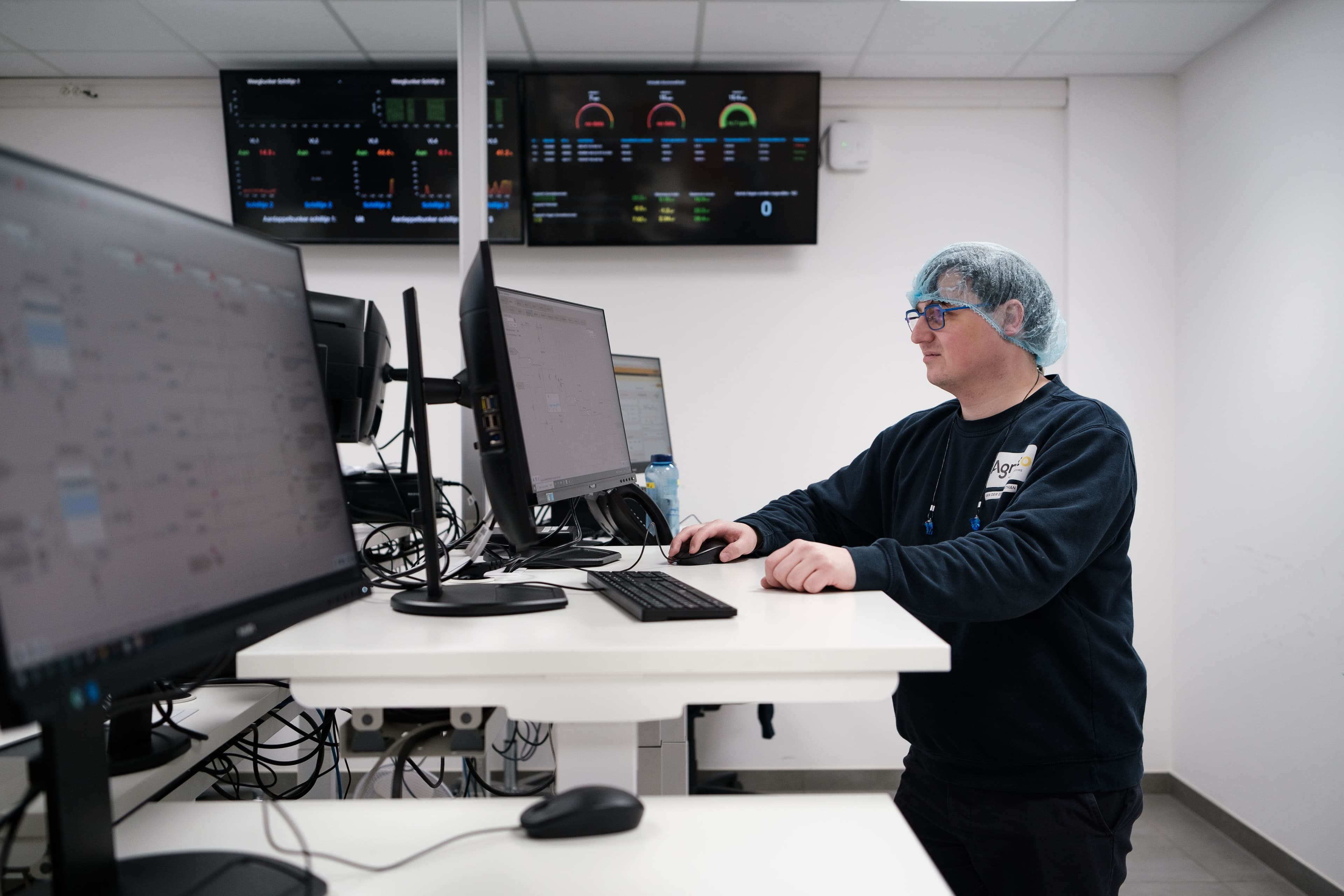 A photo of a Nathan Van der Eecken, process engineer at Agristo, using Grafana dashboards.